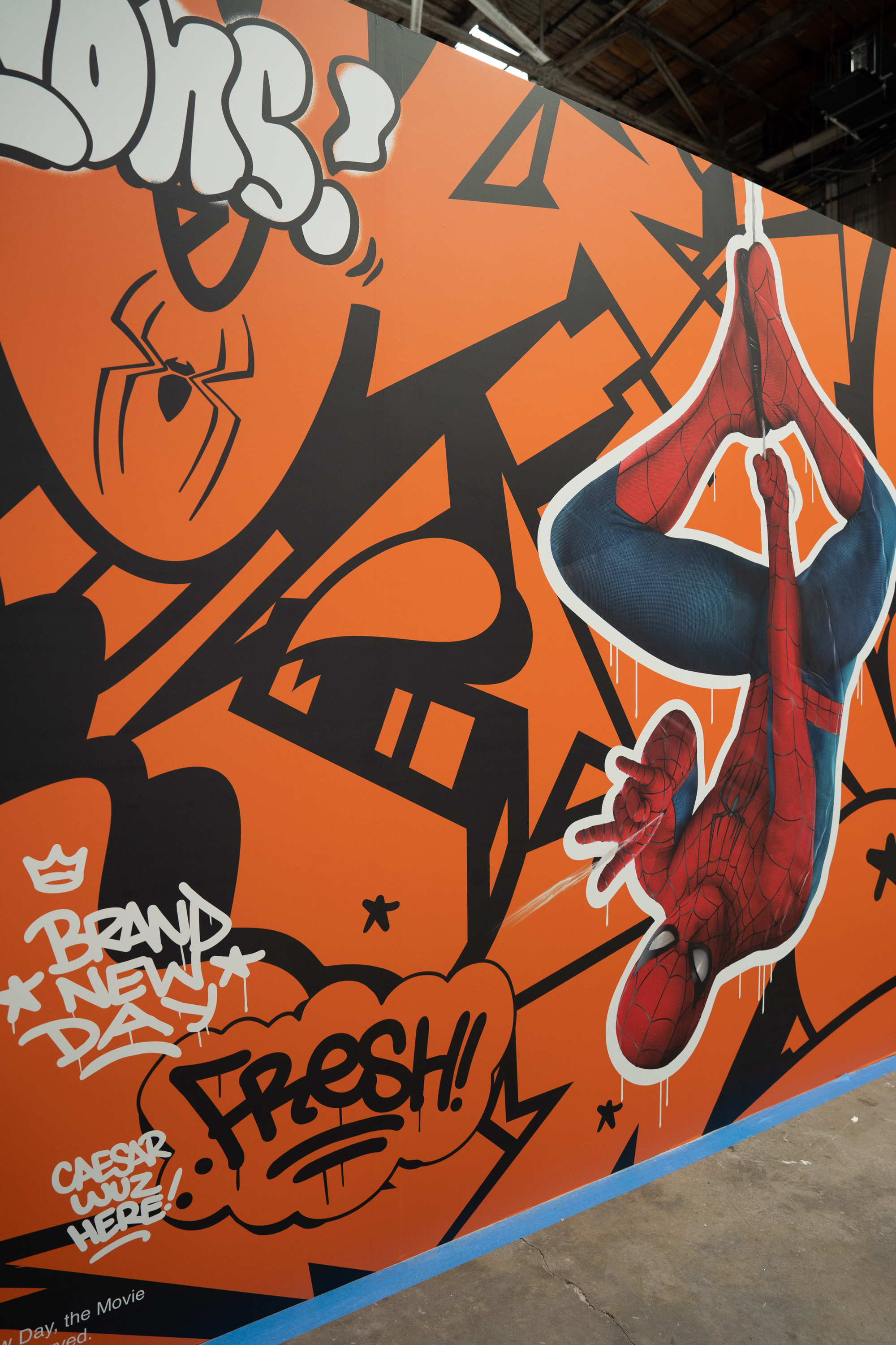 Close-up of the Spider-Man hanging graphic on the orange container wall