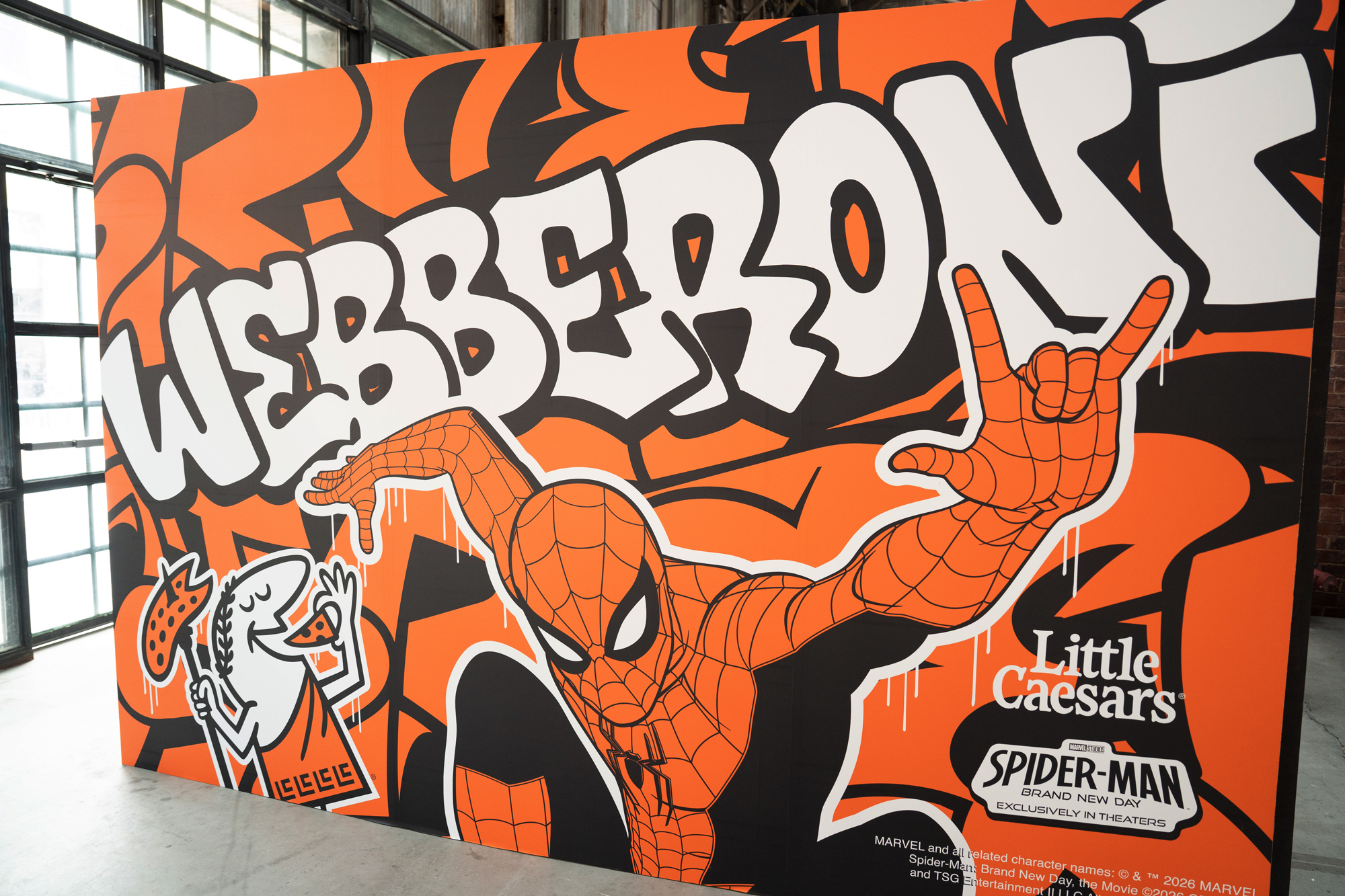 Large-format Webberoni wall graphic with Spider-Man reaching for a slice