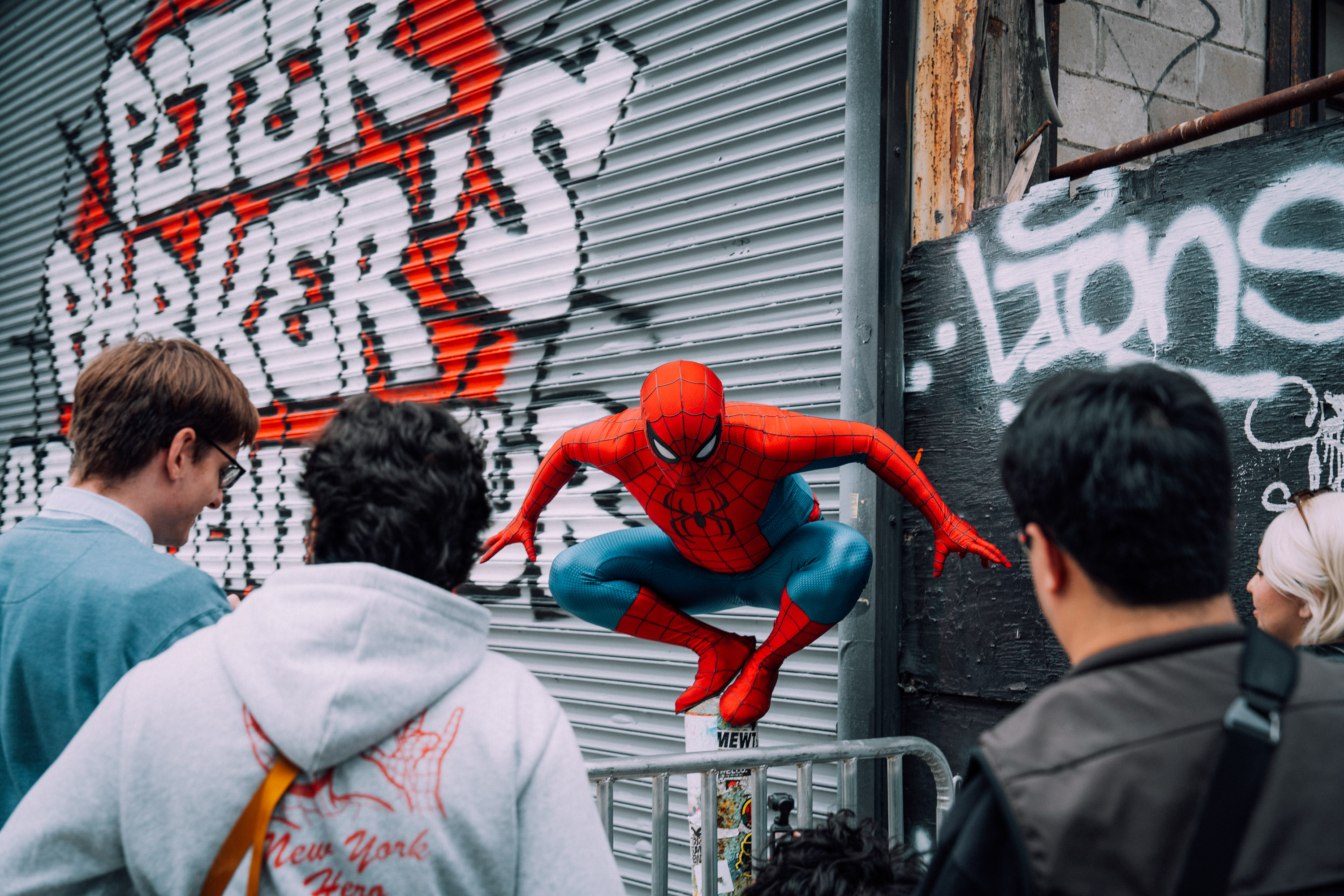 Spider-Man perched above the crowd at the gate mural